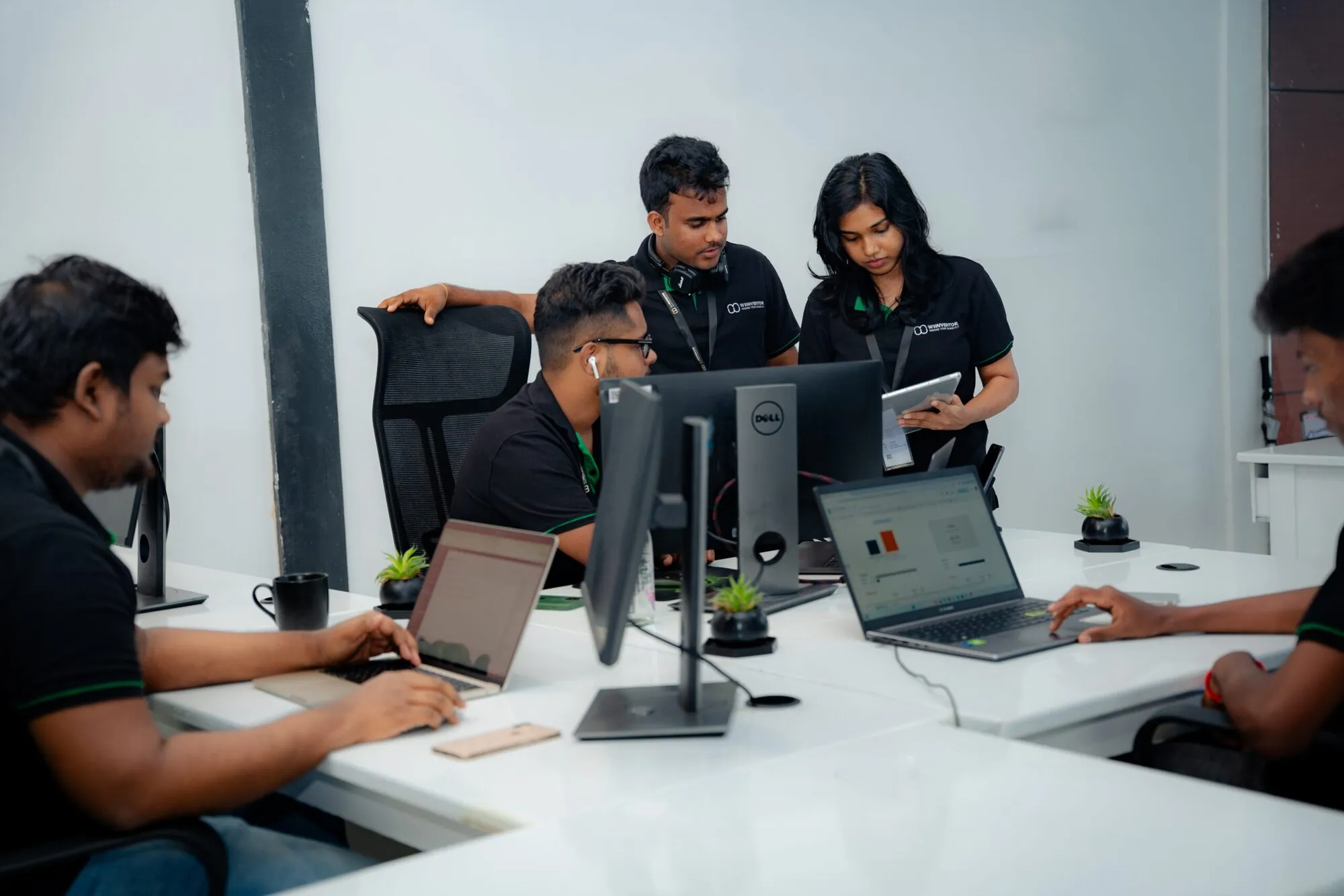 W3Inventor team clustered around a monitor and tablet, planning a sprint in the Colombo studio