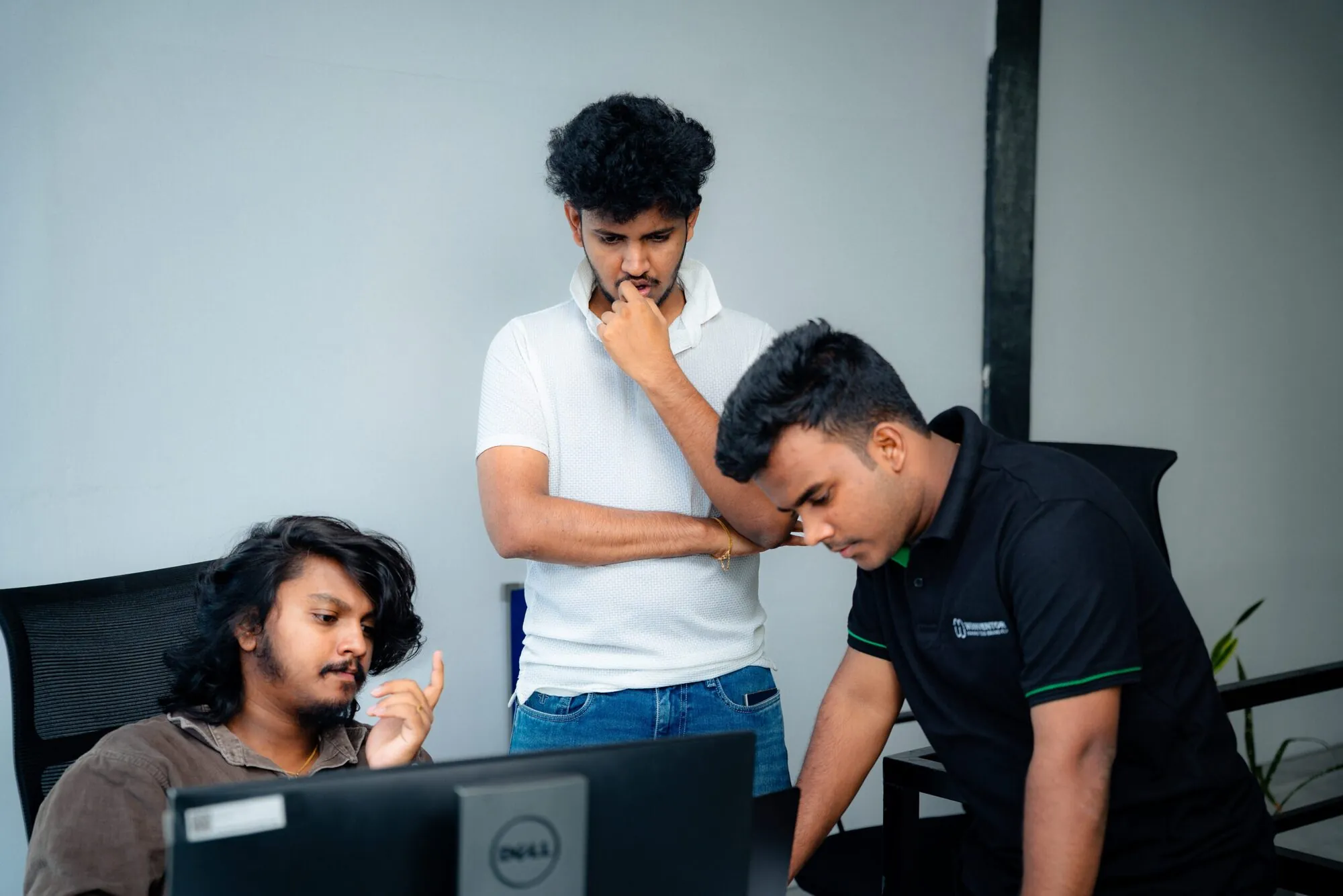 Three W3Inventor colleagues studying a screen during a design review session