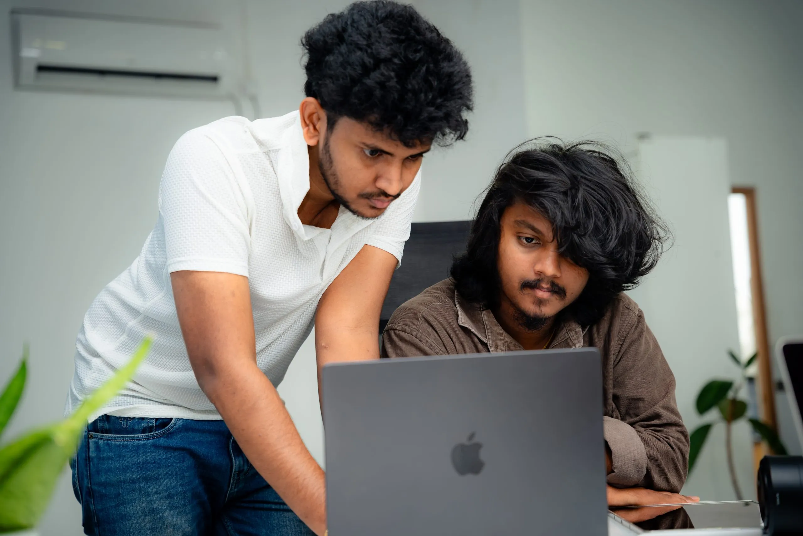 social media marketing – Two W3Inventor colleagues looking at a laptop together