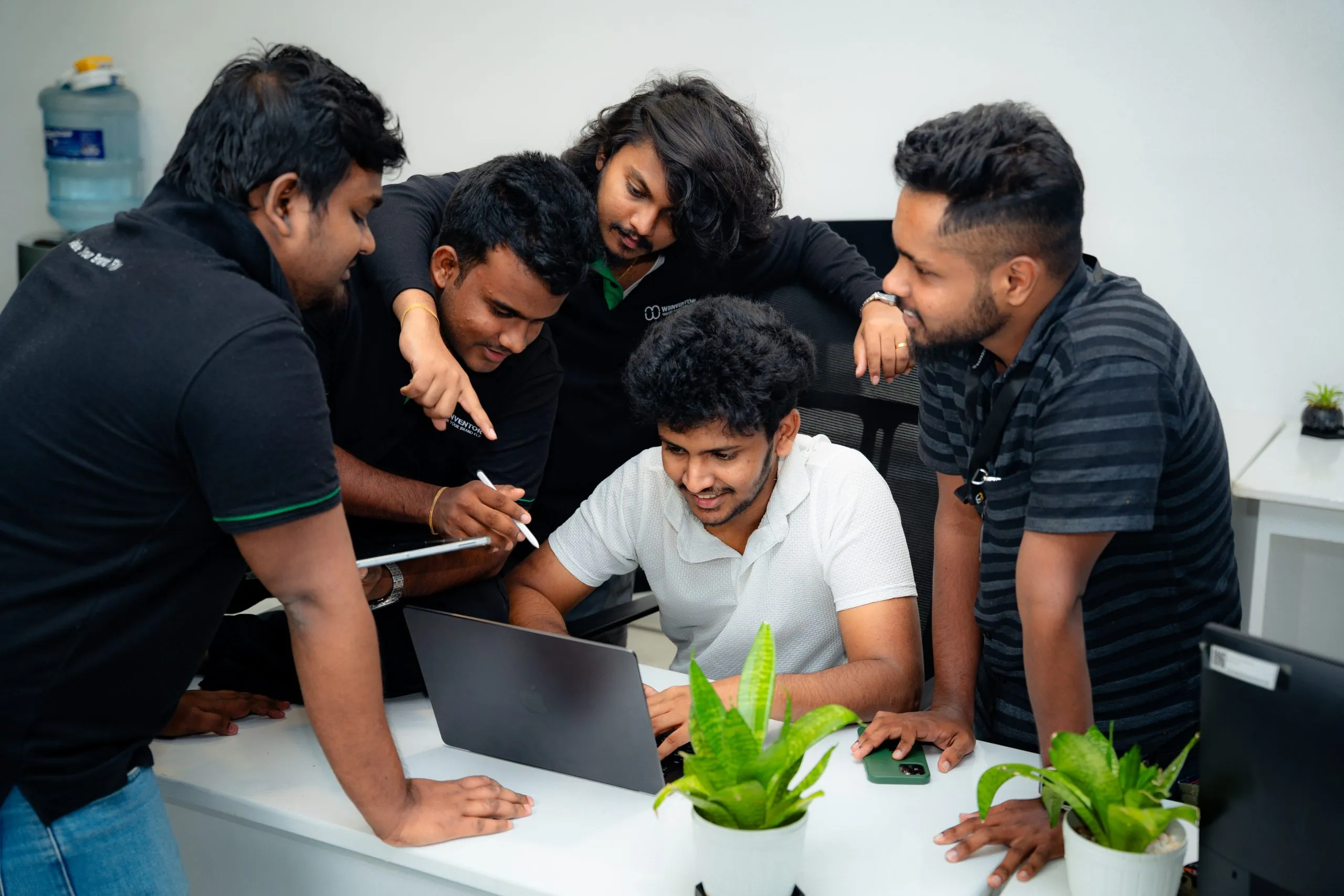 360 design solutions – W3Inventor team huddled around a laptop